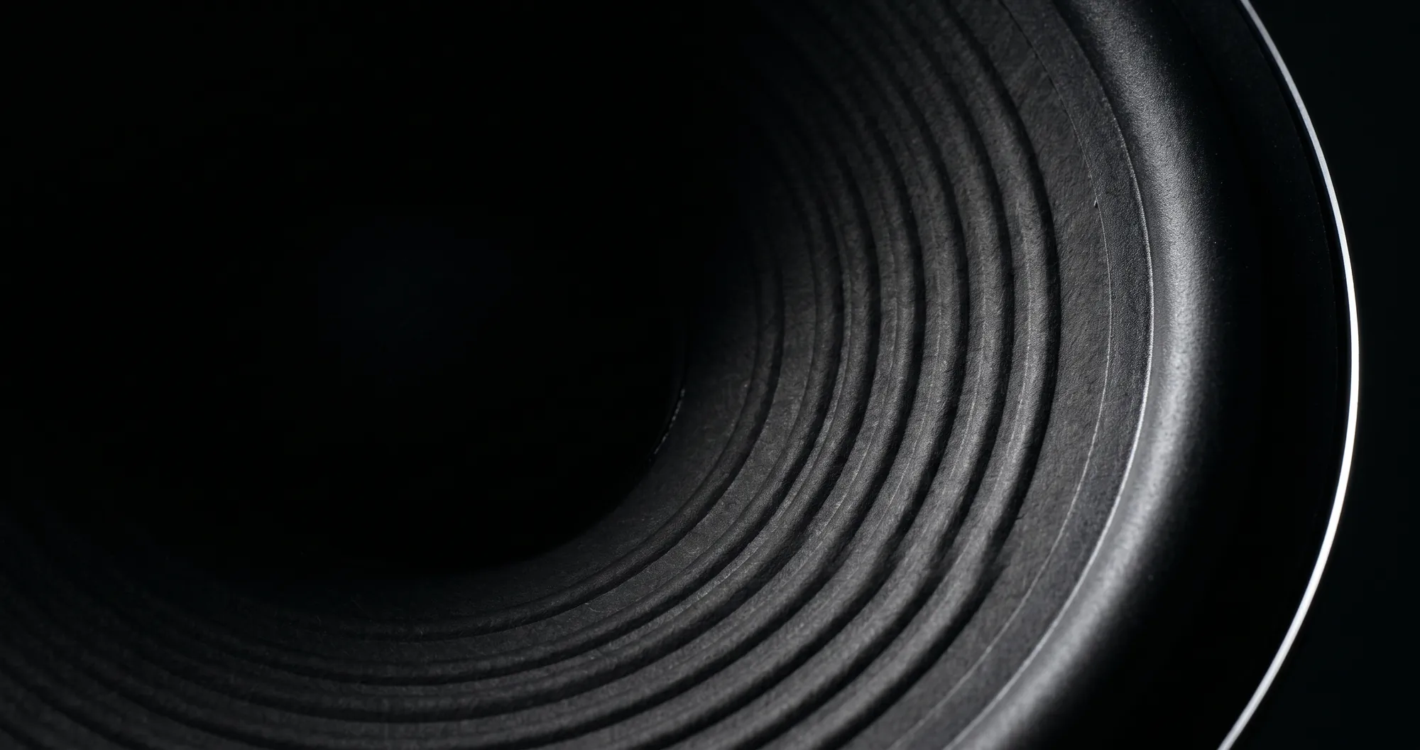 Loop Audio Works, precision audio installation in South India Loop Audio Works, precision audio installation in South India. Macro of concentric speaker cone rings lit by a narrow strip light.